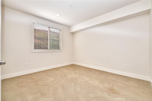 unfurnished room featuring carpet floors and baseboards