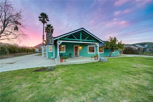 back of property with a porch and a lawn