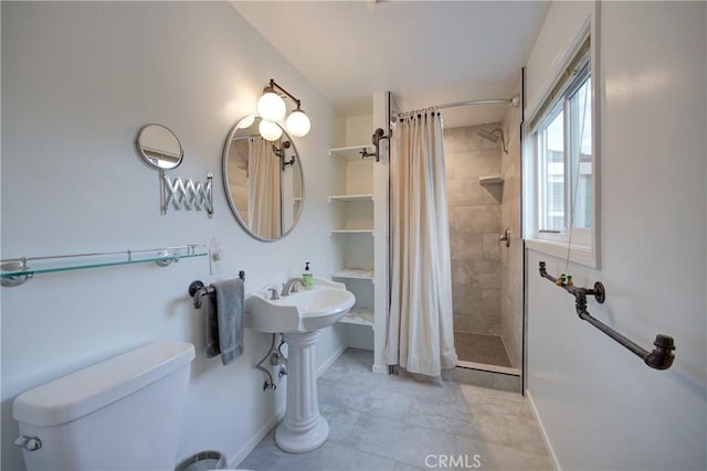 bathroom featuring toilet, baseboards, and a tile shower