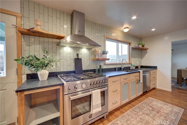 kitchen featuring wall chimney range hood, appliances with stainless steel finishes, open shelves, tasteful backsplash, and dark countertops