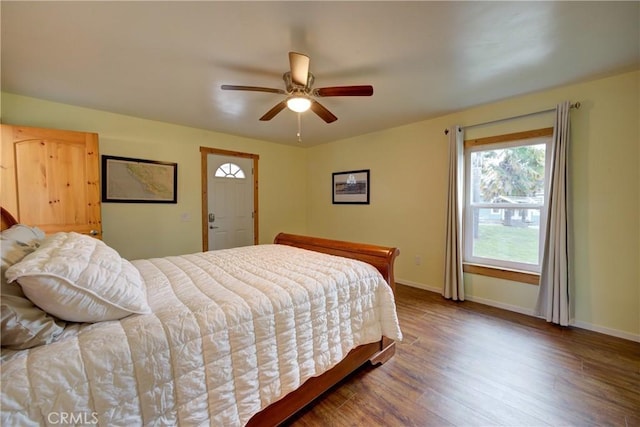 bedroom featuring ceiling fan, baseboards, and wood finished floors