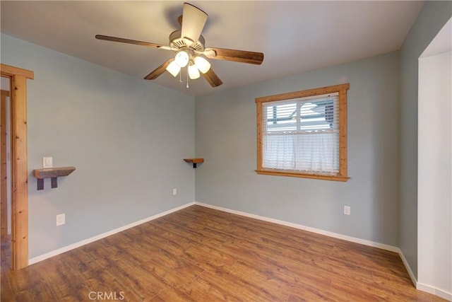 unfurnished room with a ceiling fan, baseboards, and wood finished floors