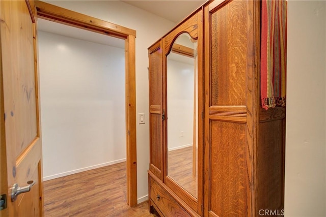 hallway with baseboards and wood finished floors