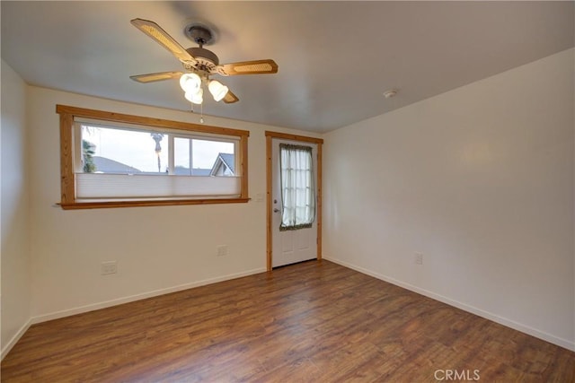 spare room with ceiling fan, wood finished floors, and baseboards