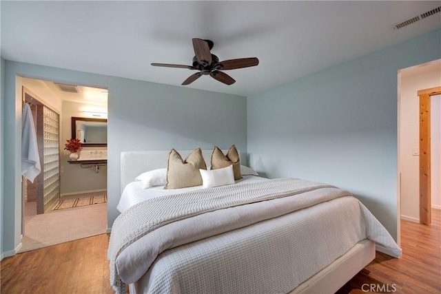 bedroom with visible vents, baseboards, and wood finished floors