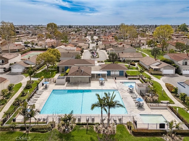 community pool featuring a residential view, a patio, and fence