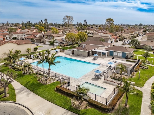 community pool featuring a residential view, fence, and a patio