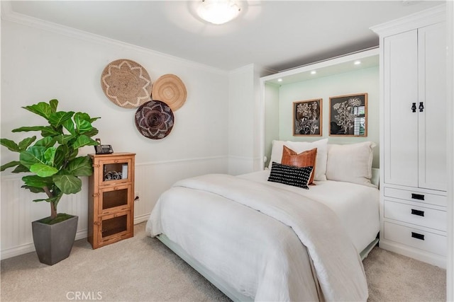 bedroom featuring crown molding and light colored carpet