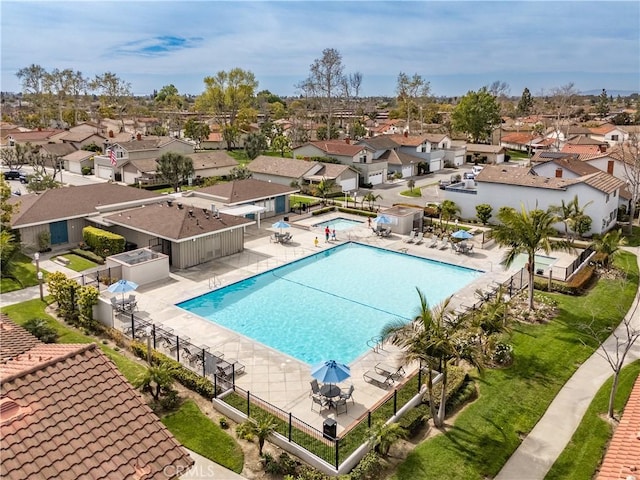 community pool with a patio area, a residential view, and fence