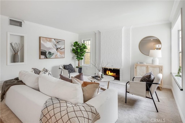 living area featuring carpet, crown molding, a fireplace, visible vents, and baseboards