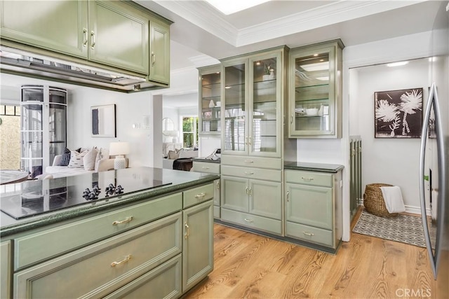 kitchen with dark countertops, black electric stovetop, crown molding, light wood-type flooring, and green cabinets