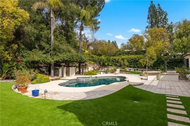 outdoor pool with a yard and a patio area