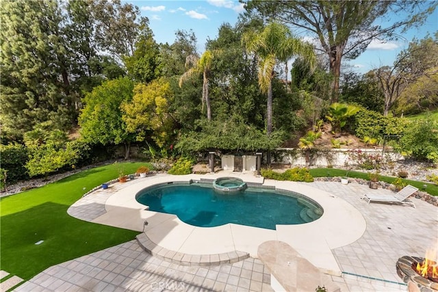 view of swimming pool with a patio area, a pool with connected hot tub, an outdoor fire pit, and a lawn