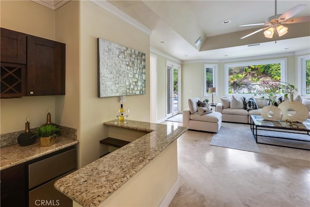 living room featuring a tray ceiling, recessed lighting, visible vents, ornamental molding, and a ceiling fan