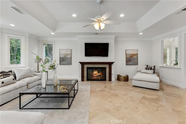 living room with a tray ceiling, visible vents, a ceiling fan, and recessed lighting