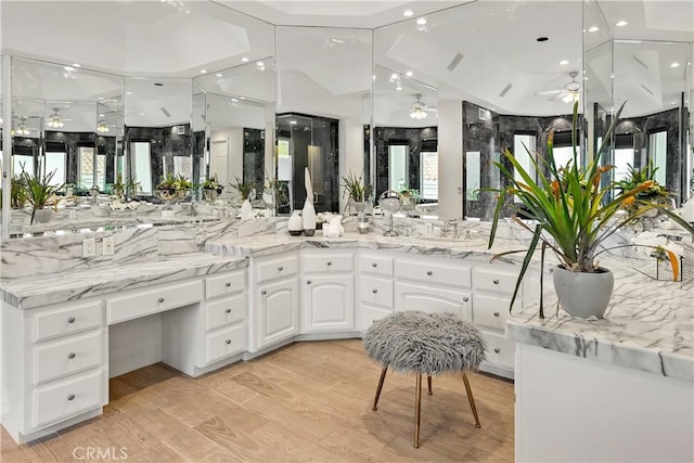 bathroom featuring wood finished floors, a ceiling fan, vanity, and a shower