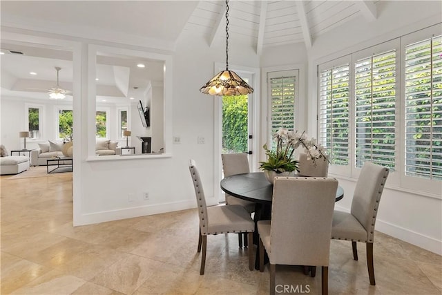 dining room with lofted ceiling with beams, plenty of natural light, a ceiling fan, and visible vents