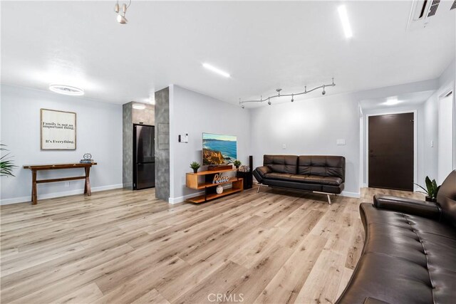 living room with light wood finished floors, baseboards, visible vents, and rail lighting