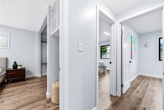 hallway with baseboards and light wood finished floors