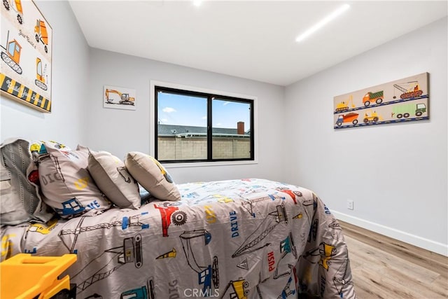 bedroom featuring baseboards and wood finished floors