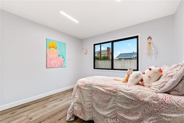 bedroom featuring baseboards and wood finished floors