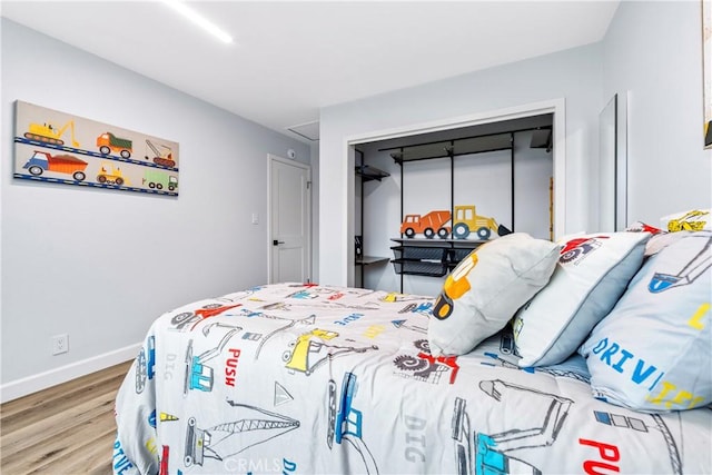 bedroom featuring a closet, baseboards, and wood finished floors