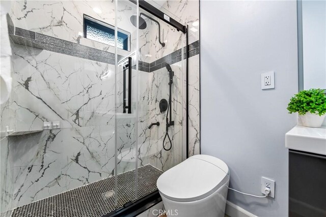 full bath featuring toilet, a marble finish shower, and vanity