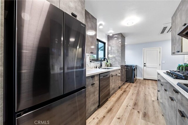 kitchen with stainless steel appliances, a sink, and modern cabinets