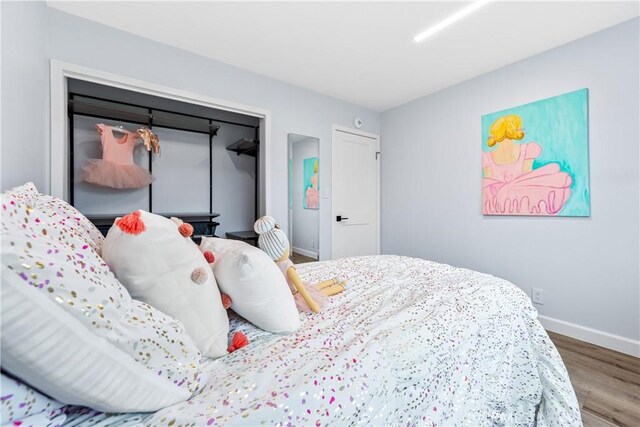 bedroom with baseboards and wood finished floors