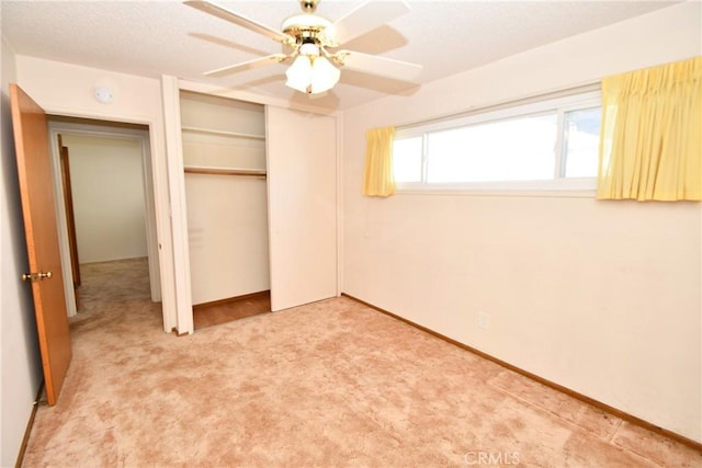 unfurnished bedroom featuring baseboards, carpet, a ceiling fan, and a closet