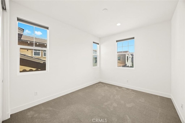 carpeted spare room featuring recessed lighting and baseboards