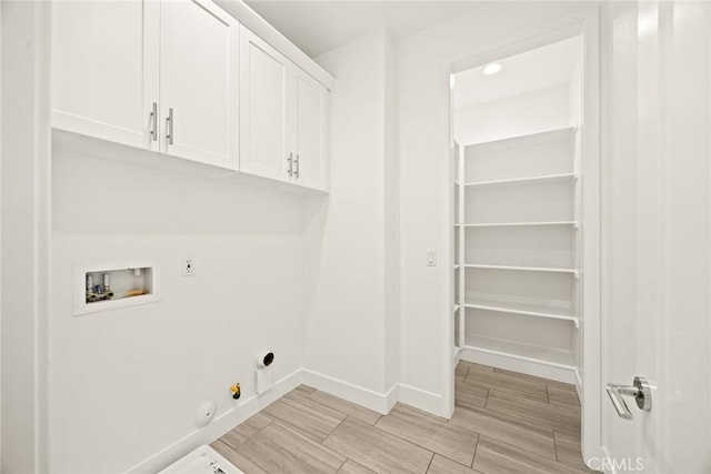 laundry area with cabinet space, baseboards, hookup for a gas dryer, hookup for a washing machine, and hookup for an electric dryer