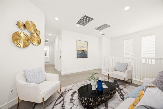 sitting room featuring carpet floors, an upstairs landing, visible vents, and recessed lighting