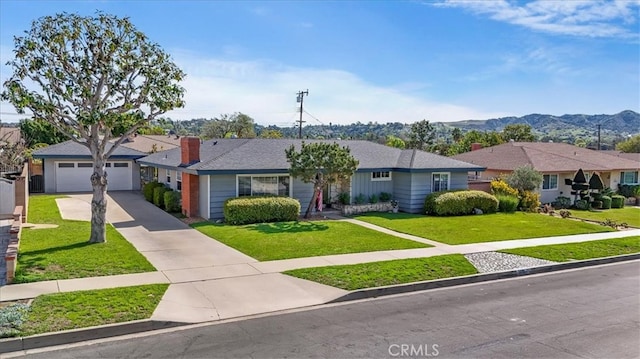 ranch-style home with a garage, concrete driveway, a residential view, a mountain view, and a front yard