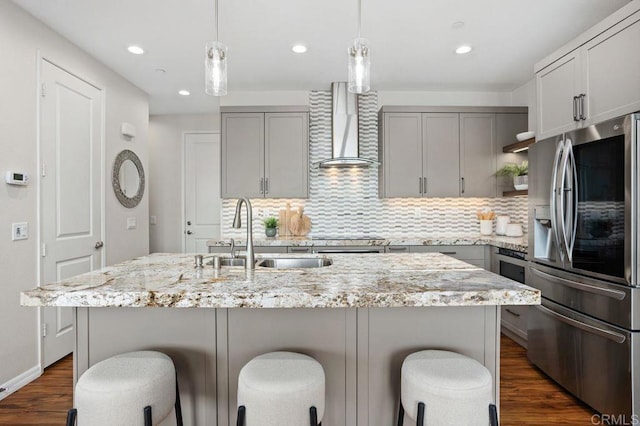 kitchen featuring gray cabinetry, wall chimney range hood, a sink, and stainless steel fridge with ice dispenser