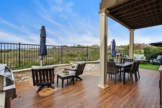 wooden deck with outdoor dining space and fence