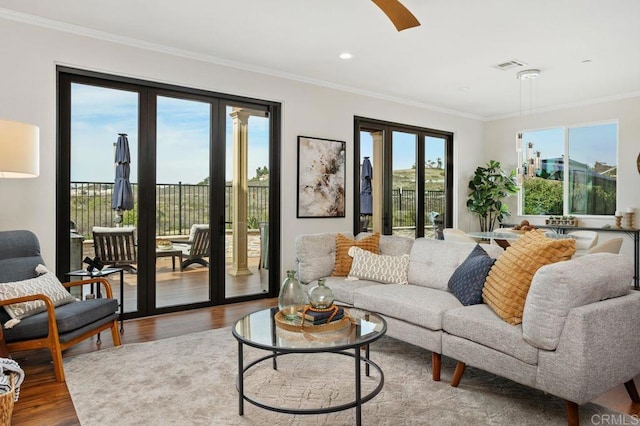 living area with french doors, recessed lighting, visible vents, ornamental molding, and wood finished floors