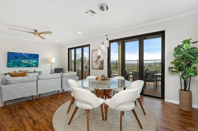 dining space featuring a healthy amount of sunlight, visible vents, crown molding, and wood finished floors