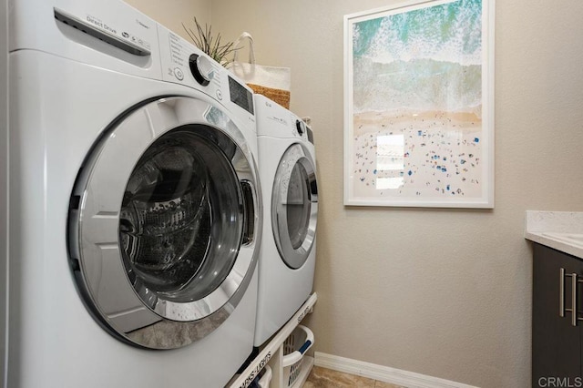 washroom featuring washing machine and dryer, laundry area, and baseboards