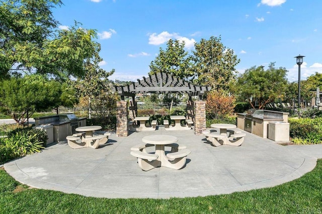 view of patio / terrace with an outdoor kitchen and a pergola