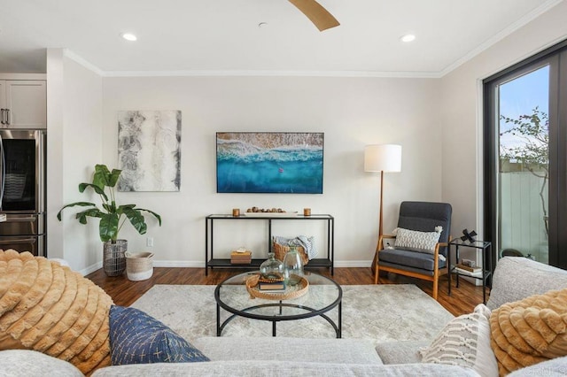 living room featuring baseboards, ornamental molding, and wood finished floors