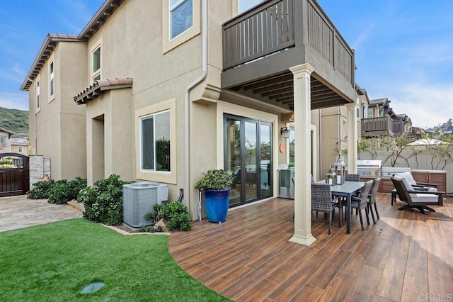 wooden terrace featuring outdoor dining area, a lawn, fence, and central air condition unit