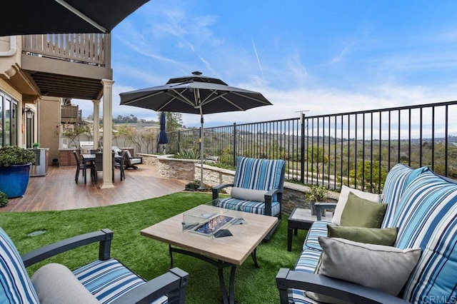 view of patio / terrace featuring an outdoor living space with a fire pit, a balcony, and fence