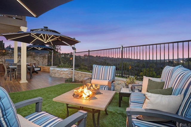 view of patio with outdoor dining space, an outdoor living space with a fire pit, and fence