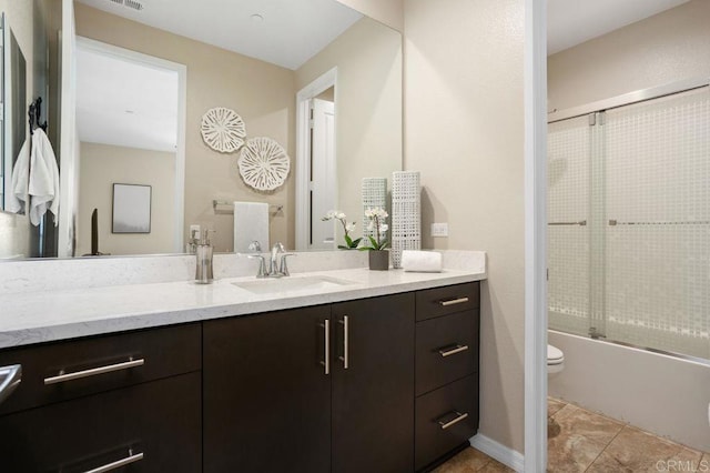 bathroom with visible vents, toilet, combined bath / shower with glass door, vanity, and tile patterned floors