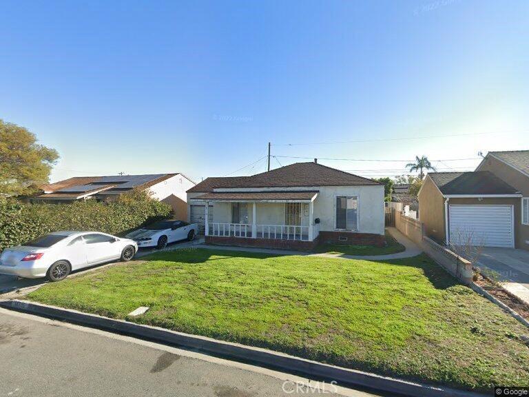 view of front of home featuring covered porch, a front yard, a garage, and stucco siding