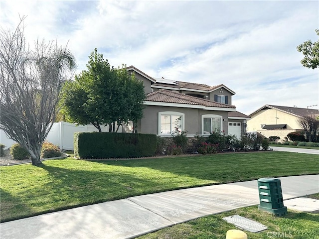 view of front of home with a garage, a tiled roof, fence, a front yard, and stucco siding