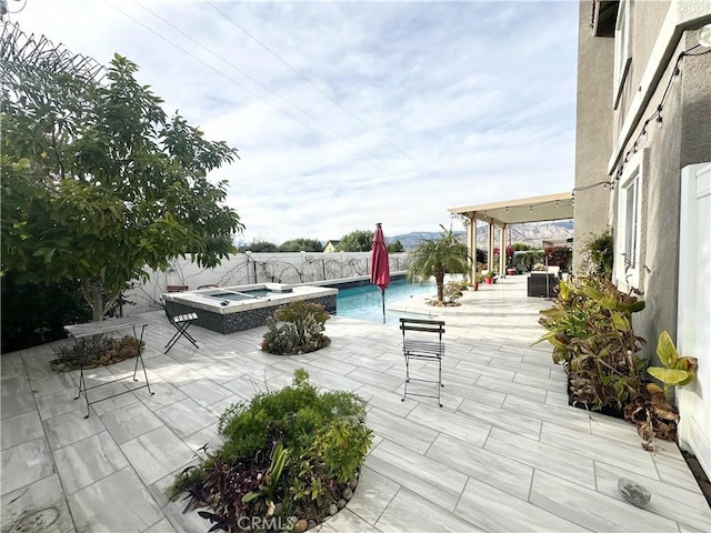 view of patio / terrace with an in ground hot tub, a fenced backyard, and a fenced in pool