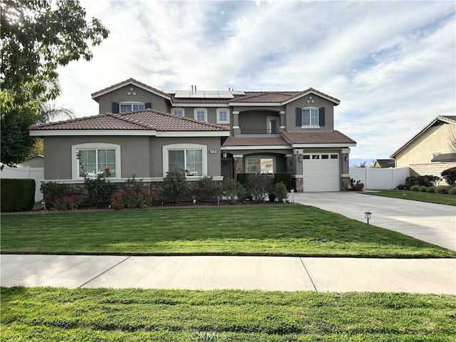 view of front facade featuring a garage, solar panels, concrete driveway, fence, and a front yard