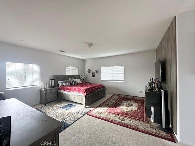 carpeted bedroom featuring visible vents